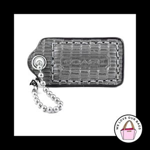 May include: A silver Coach key chain with a silver chain and a silver tag that says "Coach".