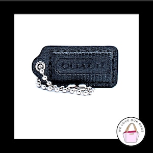 May include: A black leather Coach key chain with a silver chain and a silver ring. The key chain has the word "Coach" embossed on it.