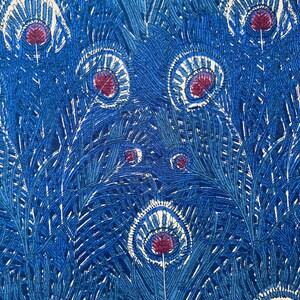 以下が含まれることがあります： スタイリッシュな孔雀の羽の繰り返し模様の生地のクローズアップ。デザインは、白と栗色のアクセントが施された青の色合いを特徴とし、テクスチャ感のある芸術的な外観を作り出しています。羽は対称的に配置されています。