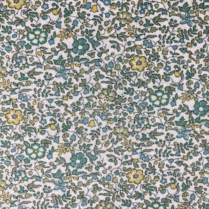 May include: A white fabric with a repeating pattern of small blue and yellow flowers on green stems. The fabric has a vintage feel.