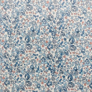 May include: A white fabric with a blue and pink floral pattern. The pattern is small and delicate, with tiny flowers and leaves.