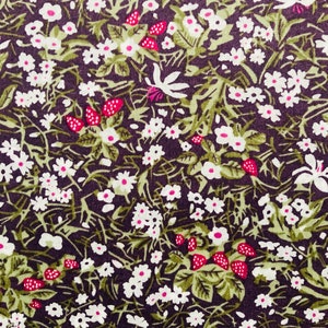 May include: A dark purple fabric with a repeating pattern of white flowers and green leaves. There are also small red berries scattered throughout the pattern.