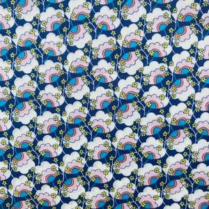 May include: A blue fabric with a repeating pattern of white, pink, and blue stylized flowers. The flowers have a yellow center and are surrounded by small green leaves.
