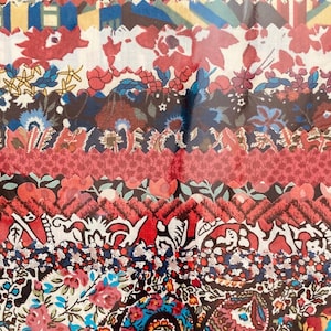 Könnte beinhalten: Eine Sammlung bunter Stoffreste mit verschiedenen Blumen- und Paisleymustern. Die Stoffe sind in einem Stapel angeordnet, wobei die oberste Schicht ein roter Stoff mit einem weißen Blumenmuster ist.
