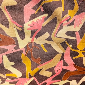 Peut inclure: Gros plan sur un tissu avec un motif abstrait. Le motif présente des formes dans des tons de rose, jaune, marron et beige sur un fond marron foncé. Les formes sont irrégulières et organiques, créant un aspect texturé.