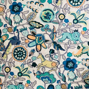 May include: A white fabric with a repeating pattern of blue, green, yellow, and orange flowers, peacocks, lions, and unicorns. The pattern is intricate and detailed.