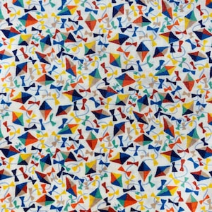 May include: White fabric with a repeating pattern of colorful kites and bows. The kites are in shades of blue, red, yellow, and green. The bows are in shades of brown and blue.
