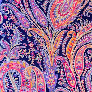 May include: A paisley patterned fabric with a dark blue background and intricate designs in shades of pink, purple, yellow, and white.