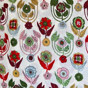 Può includere: Tessuto bianco con un motivo ripetitivo di fiori stilizzati in tonalità di rosso, verde, rosa e marrone. I fiori hanno un design fantasioso e retrò.