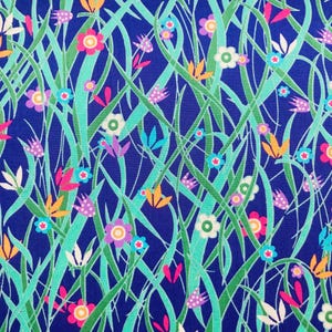 May include: A colourful fabric design with a repeating pattern of flowers and grass. The pattern features pink, white, orange, and purple flowers, with green and teal grass-like elements, set against a deep blue background.