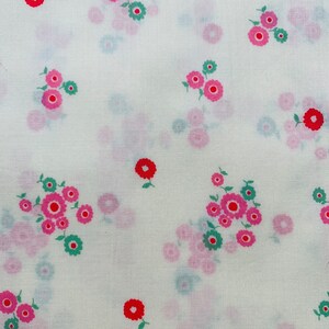 Puede incluir: Tela blanca con un patrón repetido de flores rosas y rojas con hojas verdes.