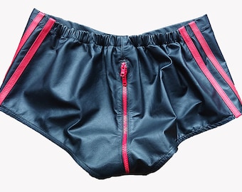 Könnte beinhalten: Schwarze Lederhose mit roten Seitenstreifen und einem roten Reißverschluss vorne.