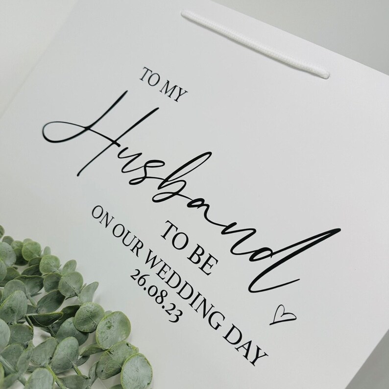 Puede incluir: Bolsa de regalo blanca con texto negro que dice "To my Husband to be on our wedding day 26.08.23".