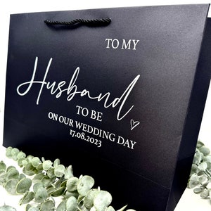 Puede incluir: Bolsa de regalo negra con texto blanco que dice "To my Husband to be on our wedding day 17.08.2023".