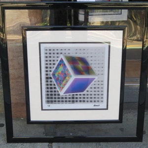 Può includere: Una stampa incorniciata di un cubo multidimensionale colorato con uno schema a griglia sullo sfondo. La stampa è firmata "Blank" e numerata "1/6".