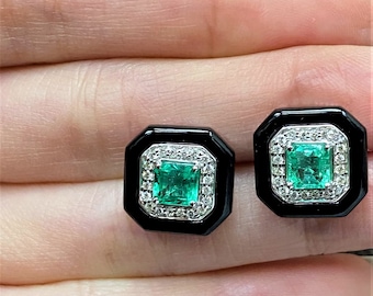 May include: A pair of square emerald stud earrings. Each earring features a vibrant green emerald center stone, surrounded by a halo of small diamonds, set in a black octagonal frame.