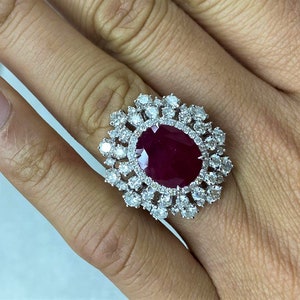 以下が含まれることがあります： 白金の指輪に、大きな楕円形のルビーが、小さなダイヤモンドのハローで囲まれている