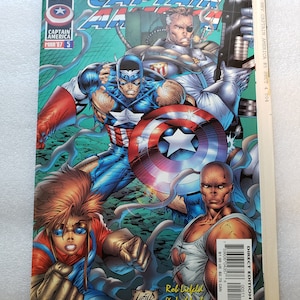May include: Comic book cover featuring Captain America in a red, white, and blue costume. He is surrounded by other characters, including a woman with red hair and a man with a black eyepatch. The cover is titled "Captain America" and has the issue number "5" printed on it. The cover also includes the text "Rob Liefeld & Jeph Loeb".
