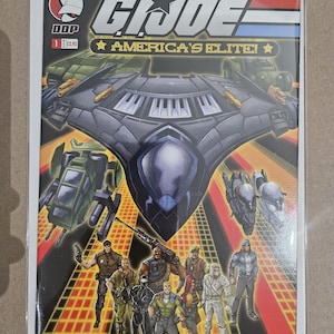 May include: A comic book cover featuring a group of action figures in front of a futuristic spaceship. The cover is titled "G.I. Joe - America's Elite!" and features the text "Data Desk Handbook - Everything you need to know about America's Elite!"