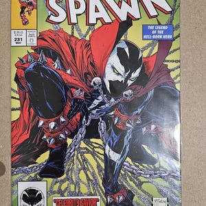 Puede incluir: Cómic de Spawn, número 231, un artículo de coleccionista. La portada presenta una ilustración detallada de Spawn en una pose dinámica, con una capa roja, guanteletes con púas y cadenas. El título del cómic está en letras grandes y en negrita.