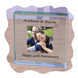 Può includere: Una cornice per foto in vetro trasparente con una foto di una coppia all'interno. La cornice ha inciso il testo "Andrew & Jayne" e "Happy 40th Anniversary".