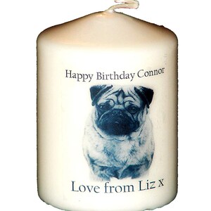 May include: White candle with a blue and white image of a pug dog. The candle has the text "Happy Birthday Connor" and "Love from Liz x" printed on it.