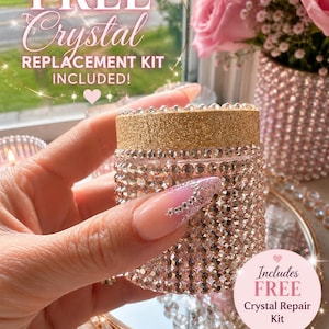 May include: A cylindrical container covered in small, clear, reflective crystals with a gold glitter lid. The text on the image reads: FREE Crystal REPLACEMENT KIT INCLUDED! and Includes FREE Crystal Repair Kit.