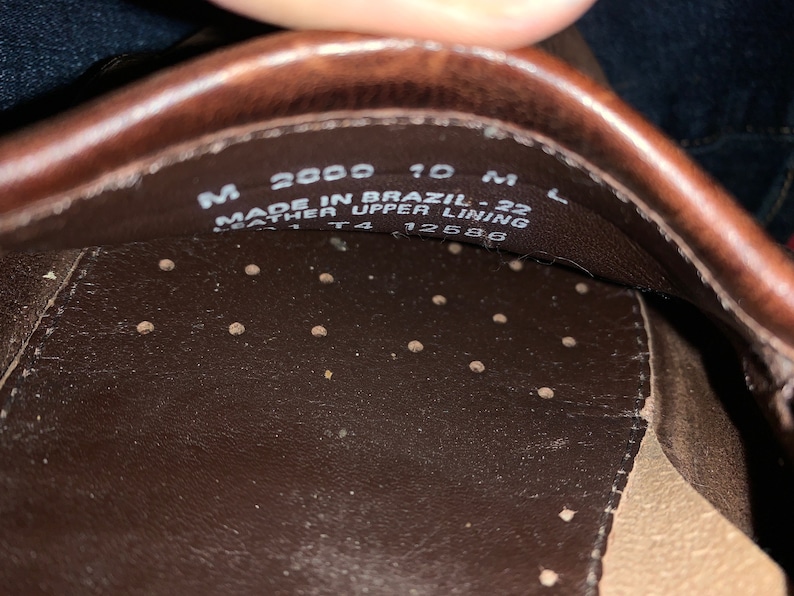 Peut inclure: Gros plan de l'int&eacute;rieur d'une chaussure en cuir marron. La chaussure est &eacute;tiquet&eacute;e "Made in Brazil - 22 Leather Upper Lining" et porte la taille "M 2000 10 M L" et "T4 12586" imprim&eacute;s sur la semelle int&eacute;rieure.