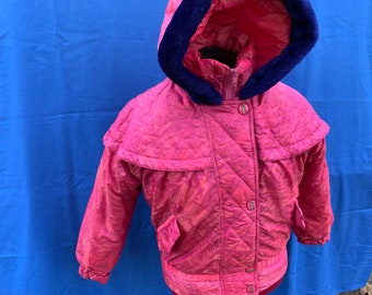 May include: A pink quilted jacket with a blue faux fur lined hood. The jacket has a zipper closure and multiple snap buttons.