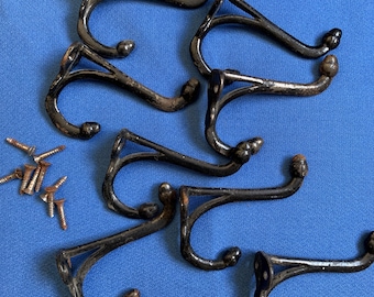 May include: Set of six black metal coat hooks with decorative ball ends and mounting screws. The hooks have a classic design, perfect for entryways or bedrooms. The hooks are made of durable metal and are ready to install.