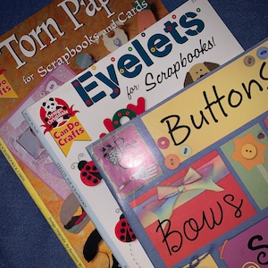 May include: Three craft books with colorful covers featuring the words "Torn Paper for Scrapbooks and Cards", "Eyelets for Scrapbooks!" and "Buttons Bows".