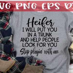 Puede incluir: Una sudadera gris con el texto "Heifer I will put you in a trunk and help people look for you Stop playin' with me" impreso en negro.