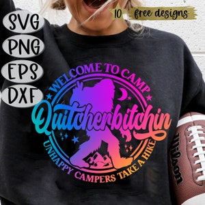 May include: A black sweatshirt with a colourful graphic design featuring a silhouette of a Bigfoot with the text "Welcome to Camp Quitcherbitchin Unhappy Campers Take a Hike".