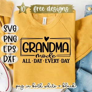 Puede incluir: Una sudadera amarilla con el texto "GRANDMA mode ALL DAY EVERY DAY" en letras negras dentro de un marco negro. Un peque&ntilde;o coraz&oacute;n est&aacute; por encima de la palabra "GRANDMA".