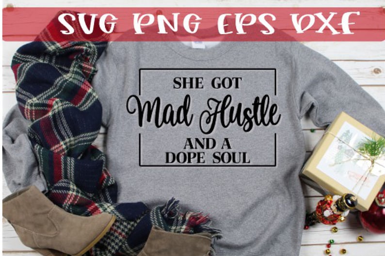 Puede incluir: Una sudadera gris con el texto "She got Mad Hustle and a Dope Soul" impreso en negro.