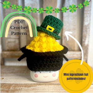 May include: A crochet pattern for a mini leprechaun hat. The hat is green with a gold buckle and is sitting on top of a pot of gold. The pattern includes instructions for making the hat and the pot of gold.