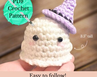 May include: A crochet pattern for a white ghost wearing a purple witch hat with a black brim. The ghost is 3.5 inches tall. The pattern is easy to follow and includes instructions for making your own cute ghost friends.