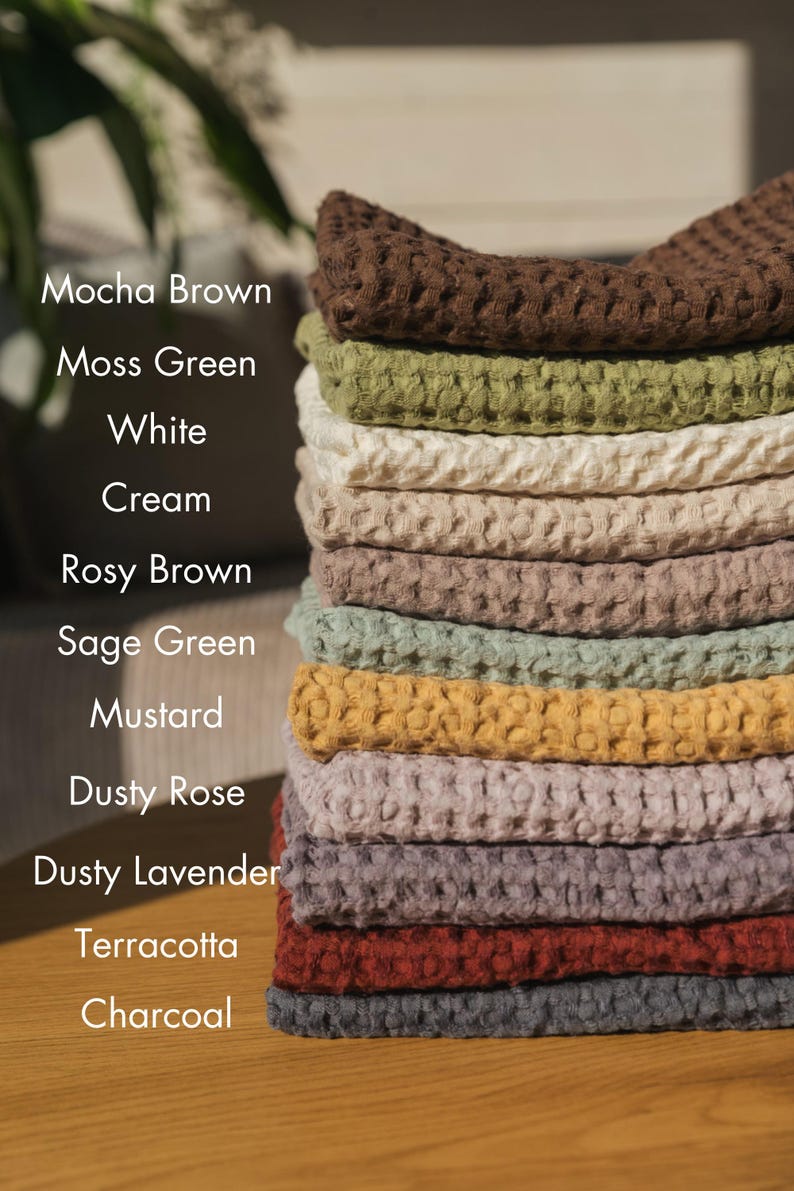 Op de afbeelding: Een stapel wafeldoeken in verschillende kleuren, waaronder mokkabruin, mosgroen, wit, cr&egrave;me, roosbruin, saliegroen, mosterd, stoffig roze, stoffig lavendel, terracotta en antraciet.