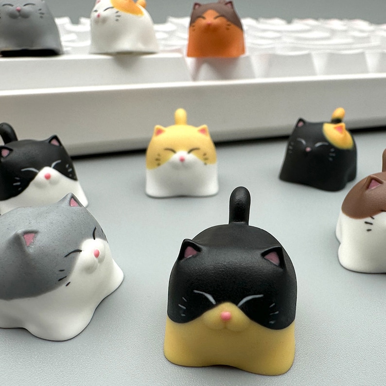 May include: A set of nine adorable cat-shaped keycaps. The keycaps are made of a soft, white plastic and feature different colored cat faces. The keycaps are perfect for adding a touch of whimsy to your keyboard.