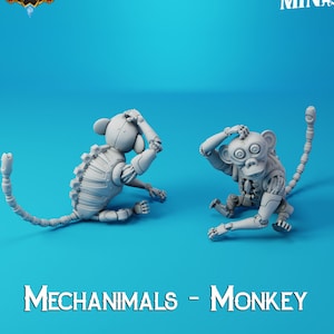 Puede incluir: Dos figuritas de mono robot de metal gris en posición sentada. El mono de la izquierda tiene la cola enroscada alrededor de su cuerpo. El mono de la derecha tiene la cola extendida detrás de él. Los monos miran ambos hacia la izquierda. El texto "MECHANIMALS - MONKEY" está impreso debajo de los monos.