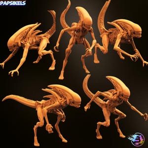 May include: Multiple orange-tan Alien figures in various poses. The figures have elongated heads, skeletal bodies, and long tails. The figures are on a dark background. The logo "Papsikels" is in the top left corner.