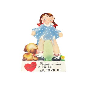 May include: Vintage Valentine's Day card featuring a cartoon girl in a blue polka dot dress, with a torn skirt. A brown puppy sits at her feet. The card has text that reads "Please be mine - or I'll be - all TORN UP" and "Dear Valentine".