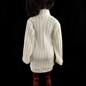 May include: A white ribbed sweater dress with long sleeves and a mock neck.