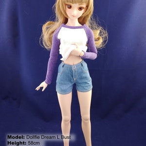 May include: A dollfie dream doll with long brown hair, wearing a white and purple shirt and blue denim shorts. The doll is 58 cm tall, has a 25 cm bust, 14 cm waist, and 23 cm hips.