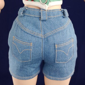 May include: Blue denim shorts with a high waist and two back pockets. The shorts have a light wash and are made of a soft, comfortable fabric.