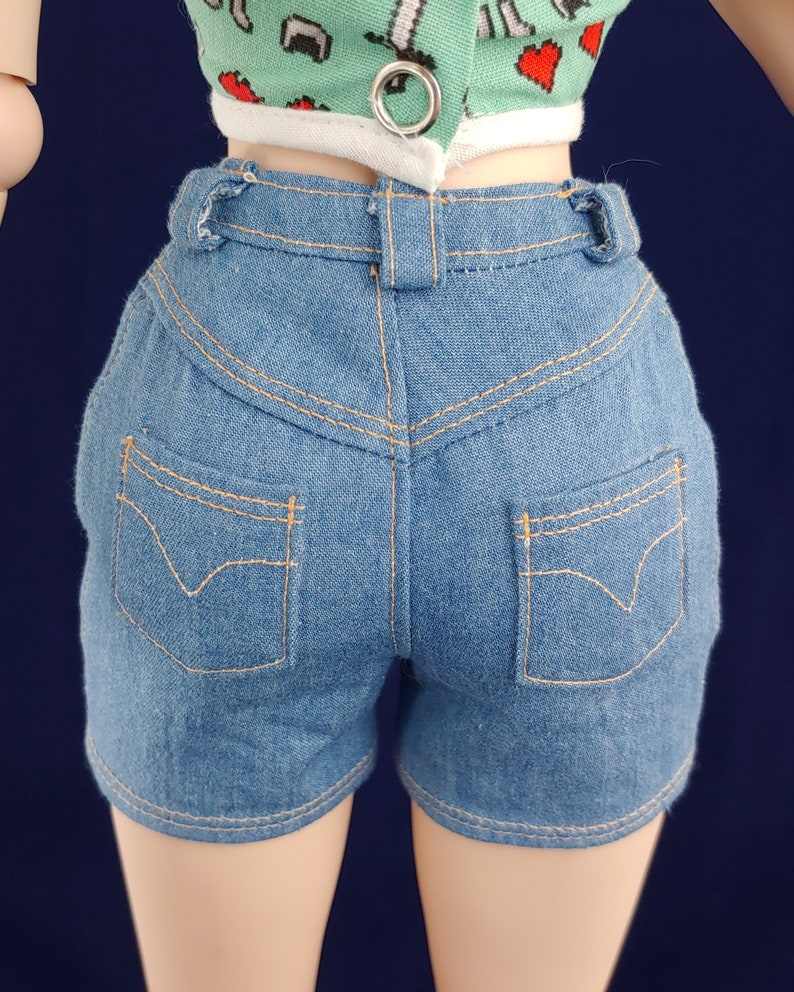 May include: Blue denim shorts with a high waist and two back pockets. The shorts have a light wash and are made of a soft, comfortable fabric.