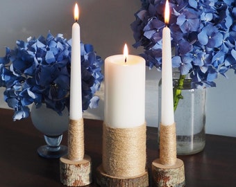 Velas rústicas de unidad decoradas con yute y candelabros de madera, decoración de boda en un granero campestre.