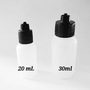 May include: Two clear plastic bottles with black caps. The smaller bottle is labeled "20 ml." and the larger bottle is labeled "30ml." The bottles are cylindrical with a rounded base and a black, ribbed cap with a small nozzle.
