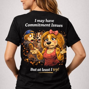 May include: Black t-shirt with the text "I may have Commitment Issues" and a cartoon dog graphic. The graphic features three dogs with surprised expressions. The phrase "But at least I try!" is printed below the graphic.