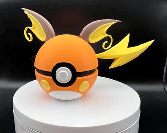 May include: A 3D printed orange and yellow Poke Ball with brown and yellow ears. The Poke Ball is sitting on a white circular base.